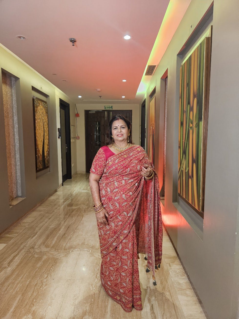 Santosh in a red and gold paisley saree